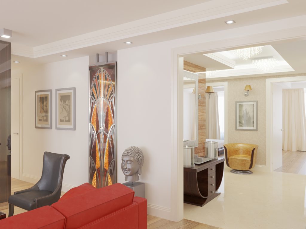 Aranżacja mieszkania salon i przedpokój w stylu art deco. Witraż wkomponowany w ścianę, rubinowa sofa w salonie, drewniana brązowa konsola w przedpokoju oraz żółty skórzany fotel