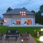 Nowoczesny dom z poddaszem użytkowym i ogrodem – widok na taras i strefę wypoczynku.