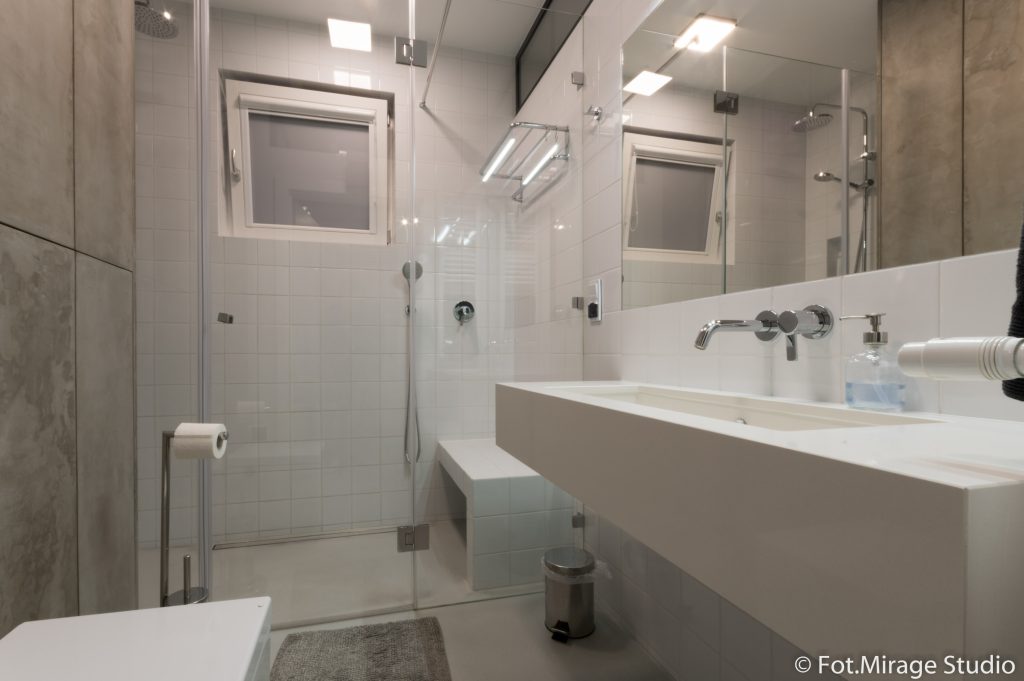 industrialne-wnetrze-mieszkanie-bielany-14 ✅ "Industrialna łazienka w mieszkaniu na Bielanach – wpuszczona umywalka obudowana białym kwarcogranitem, prysznic walk-in i laminowane fronty imitujące beton